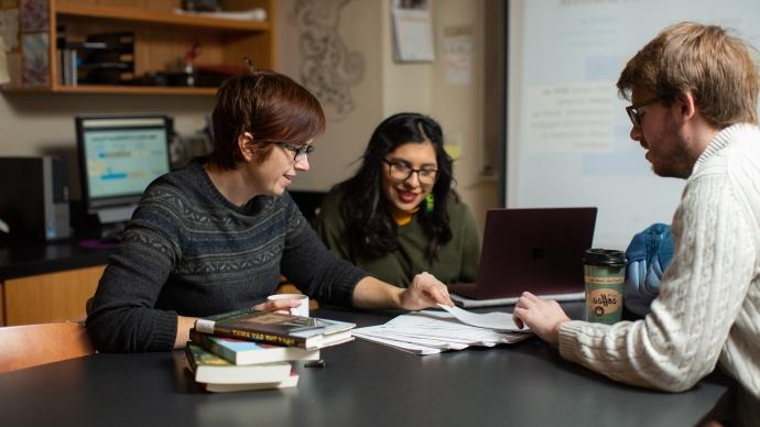 Monty McKeon and Samsara Davalos Reyes sit at a table and discuss their findings with Amy Stone.