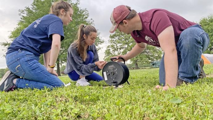 three students conduct a slug test at the Edward C. 罗伊,小. Groundwater Training Center