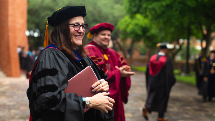 Sheryl Tynes walks past the Murchison Tower in her full regalia