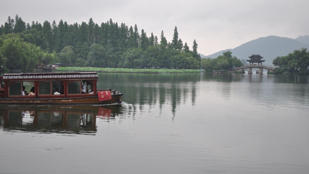 A river boat floats along a calm river in Shanghai